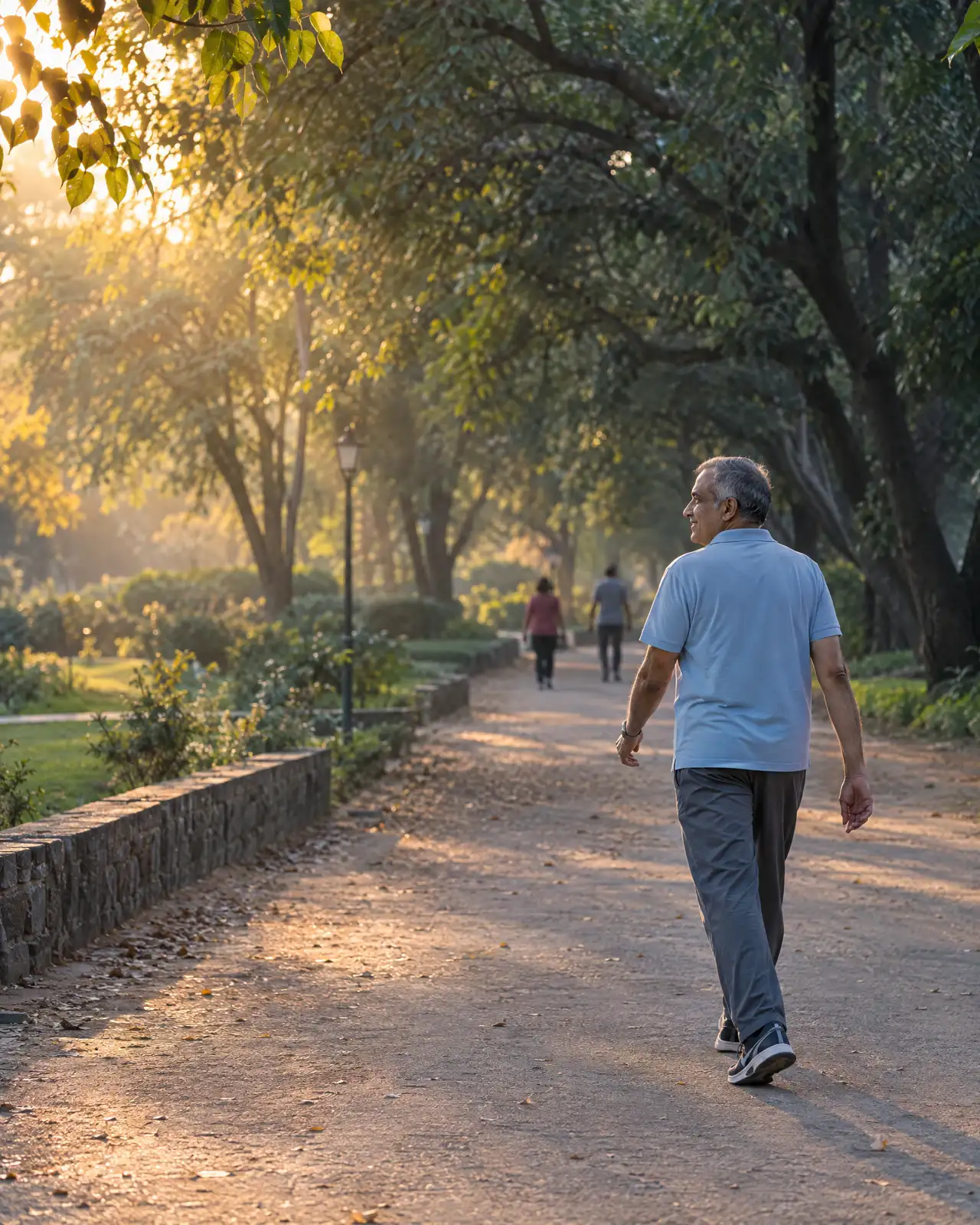 A man in his late fifties on an evening walk along a tree-lined park path.